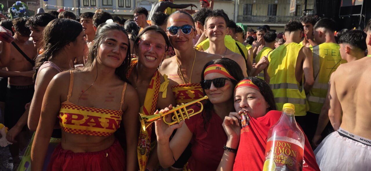Grupo de jóvenes celebrando el chupinazo en Guijuelo con banderas de España