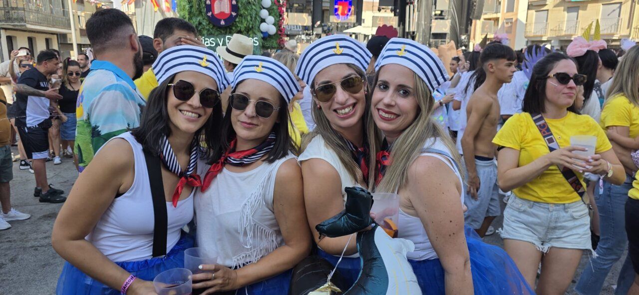 Cuatro mujeres sonrientes en el chupinazo de Guijuelo con trajes de fiesta