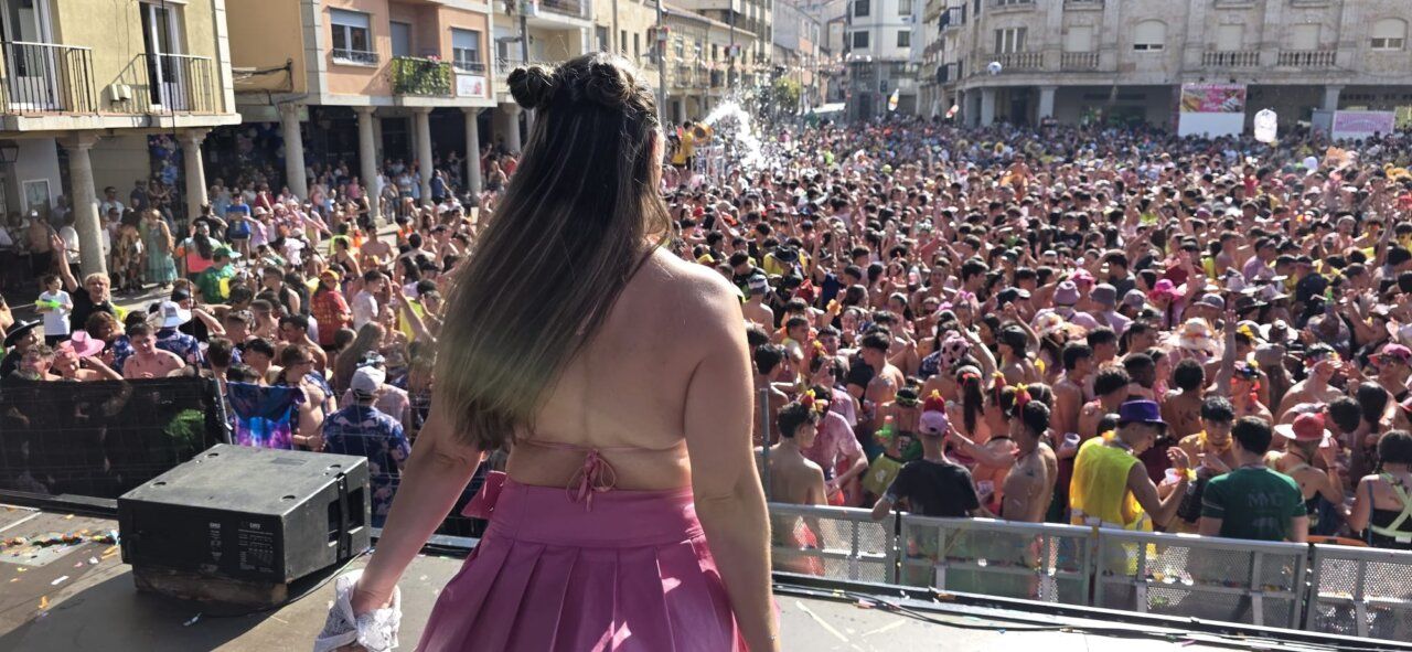 Mujer en el escenario durante el chupinazo de Guijuelo con multitud de gente