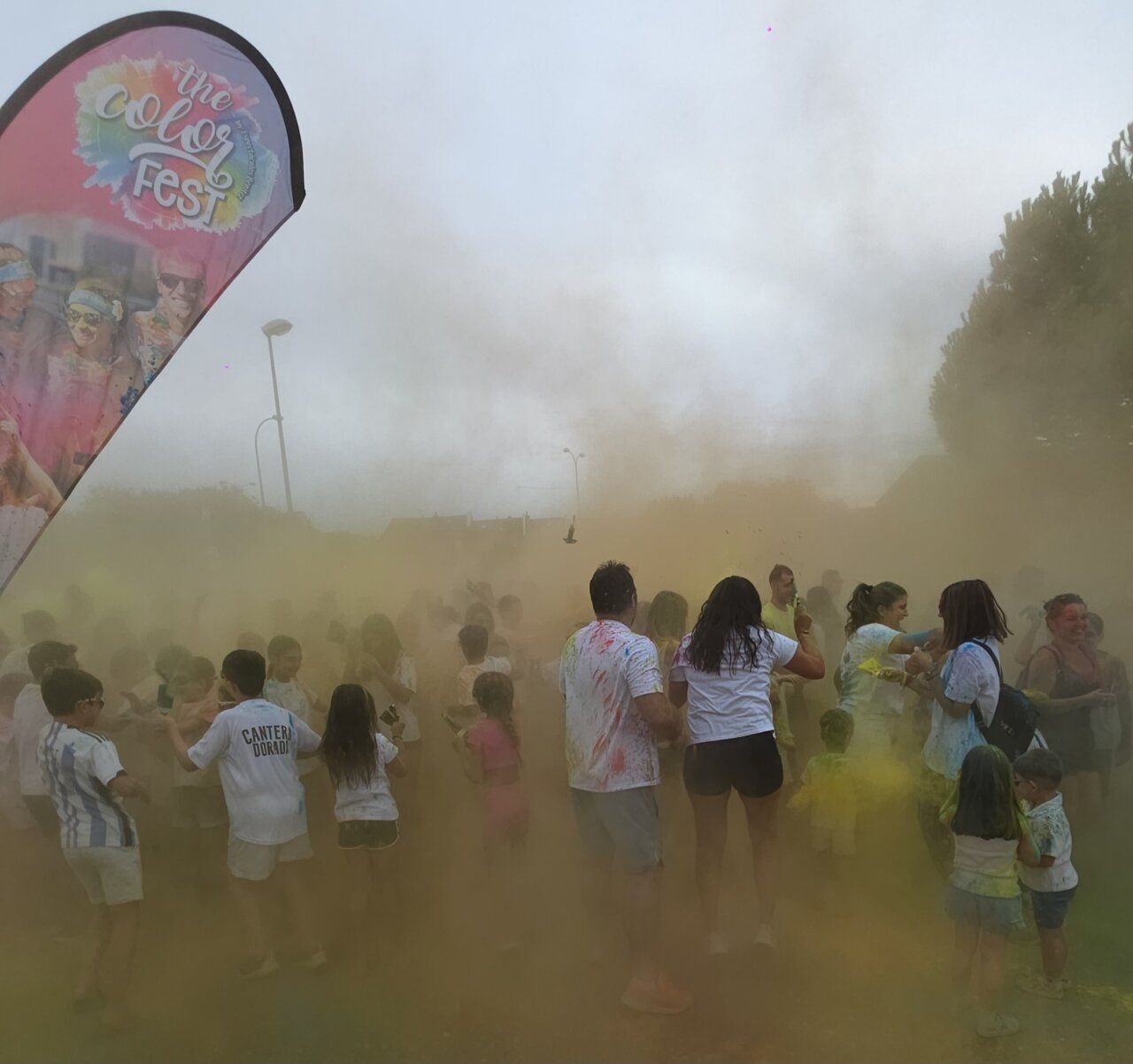 Participantes en la Color Party de Villamayor lanzando polvos de colores.