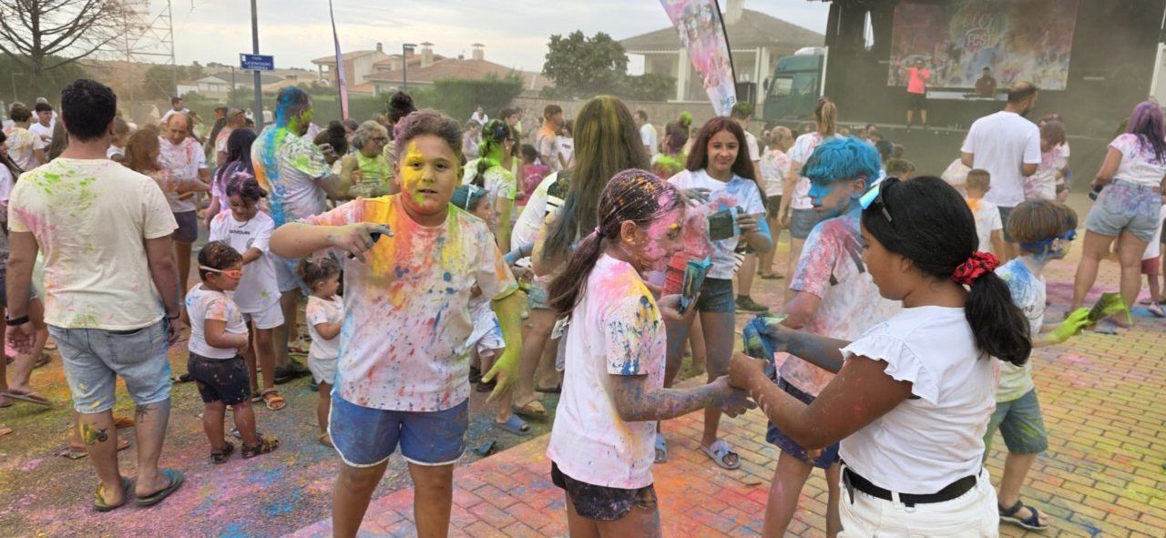 Niños y adultos disfrutando de la Color Party en Villamayor con polvos de colores