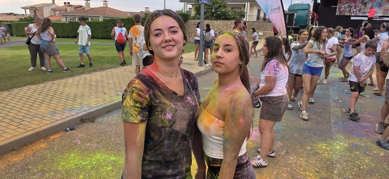 Dos jóvenes sonrientes cubiertas de polvos de colores en la Color Party