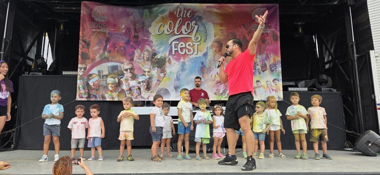 Niños y adultos disfrutando de la Color Party en Villamayor con polvos de colores
