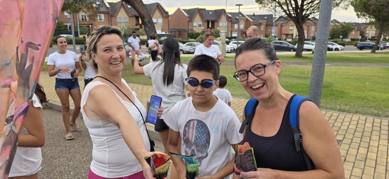 Participantes sonrientes en la Color Party de Villamayor con polvos de colores
