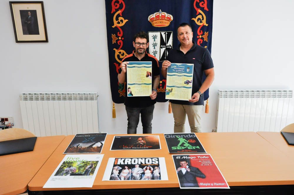 Dos hombres sosteniendo carteles de las fiestas de Santo Domingo de Guzmán