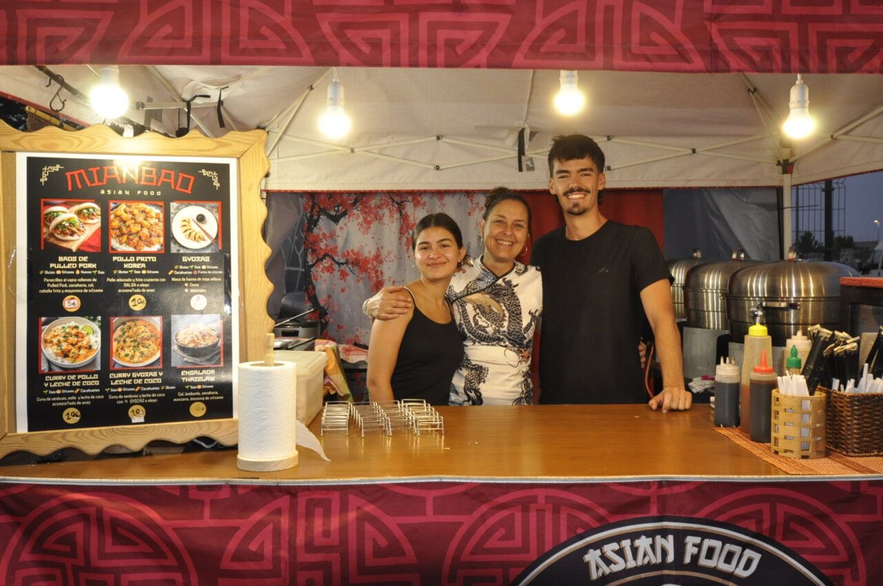 Tres personas sonrientes en un puesto de comida asiática en Aldeatejada