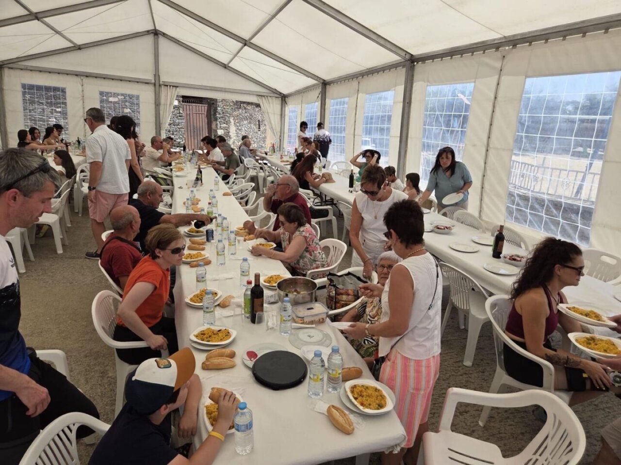 Personas disfrutando de una comida en una carpa durante las fiestas patronales