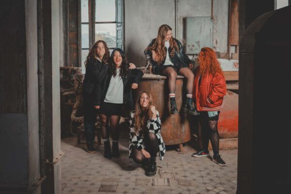 Las Titis posando en un ambiente industrial, sonriendo y divirtiéndose.