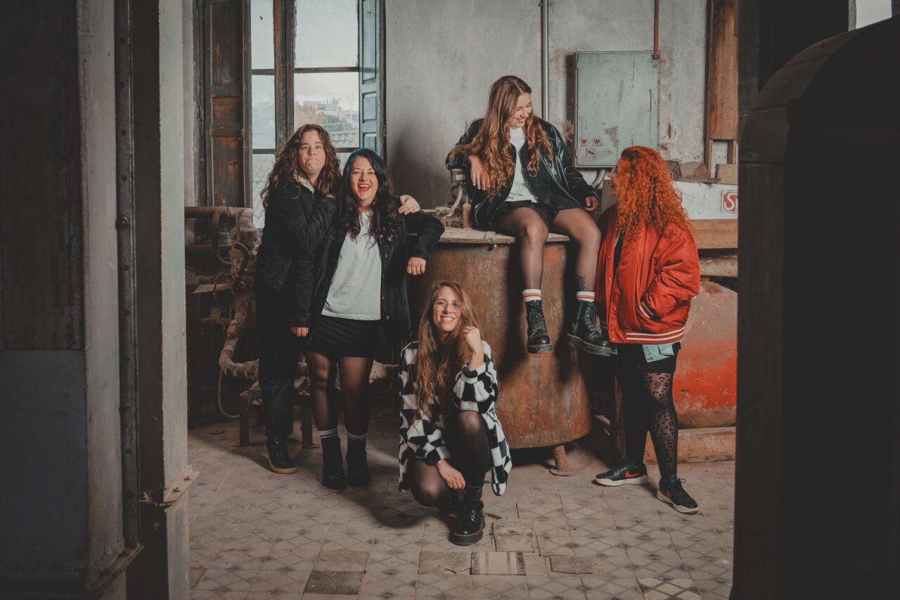 Las Titis posando en un ambiente industrial, sonriendo y divirtiéndose.