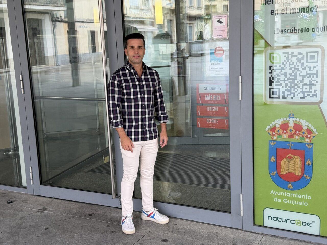 Hombre de pie frente al Ayuntamiento de Guijuelo con el sello Más Bici visible.