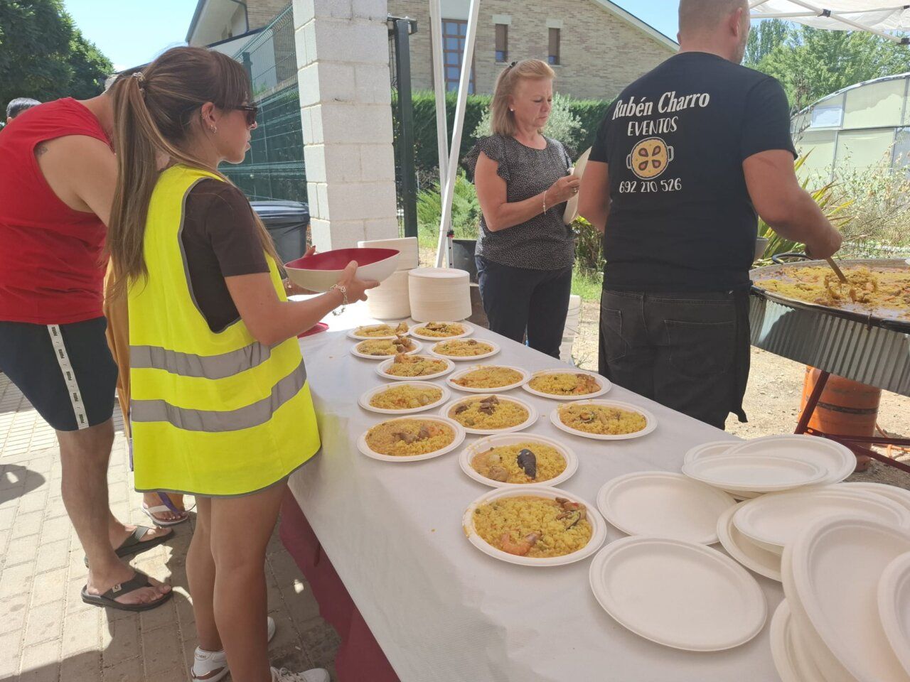 Mujer sirviendo paella en evento solidario en Carbajosa de la Sagrada