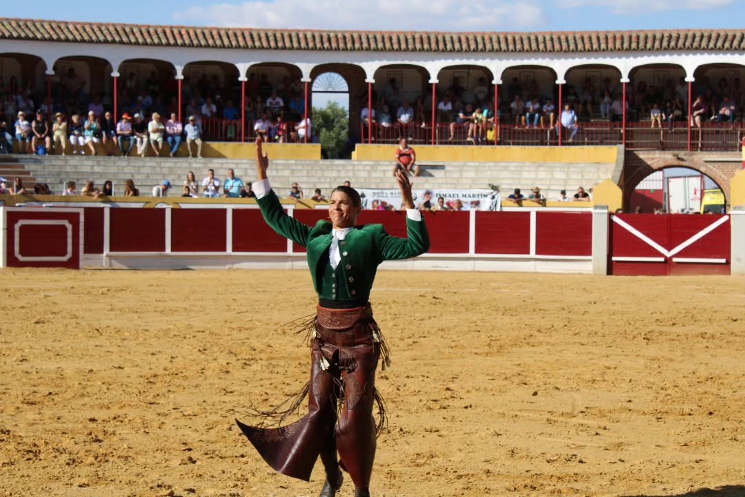 Torero en traje de luces en la arena con público al fondo