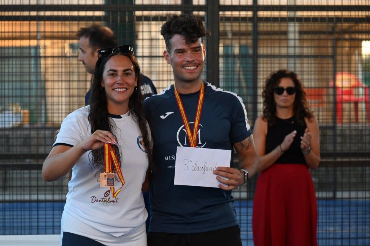 Pareja de jugadores sosteniendo medallas en torneo de pádel