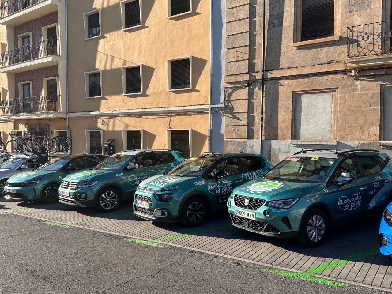Varios coches de Autoescuelas El Pilar estacionados en una calle