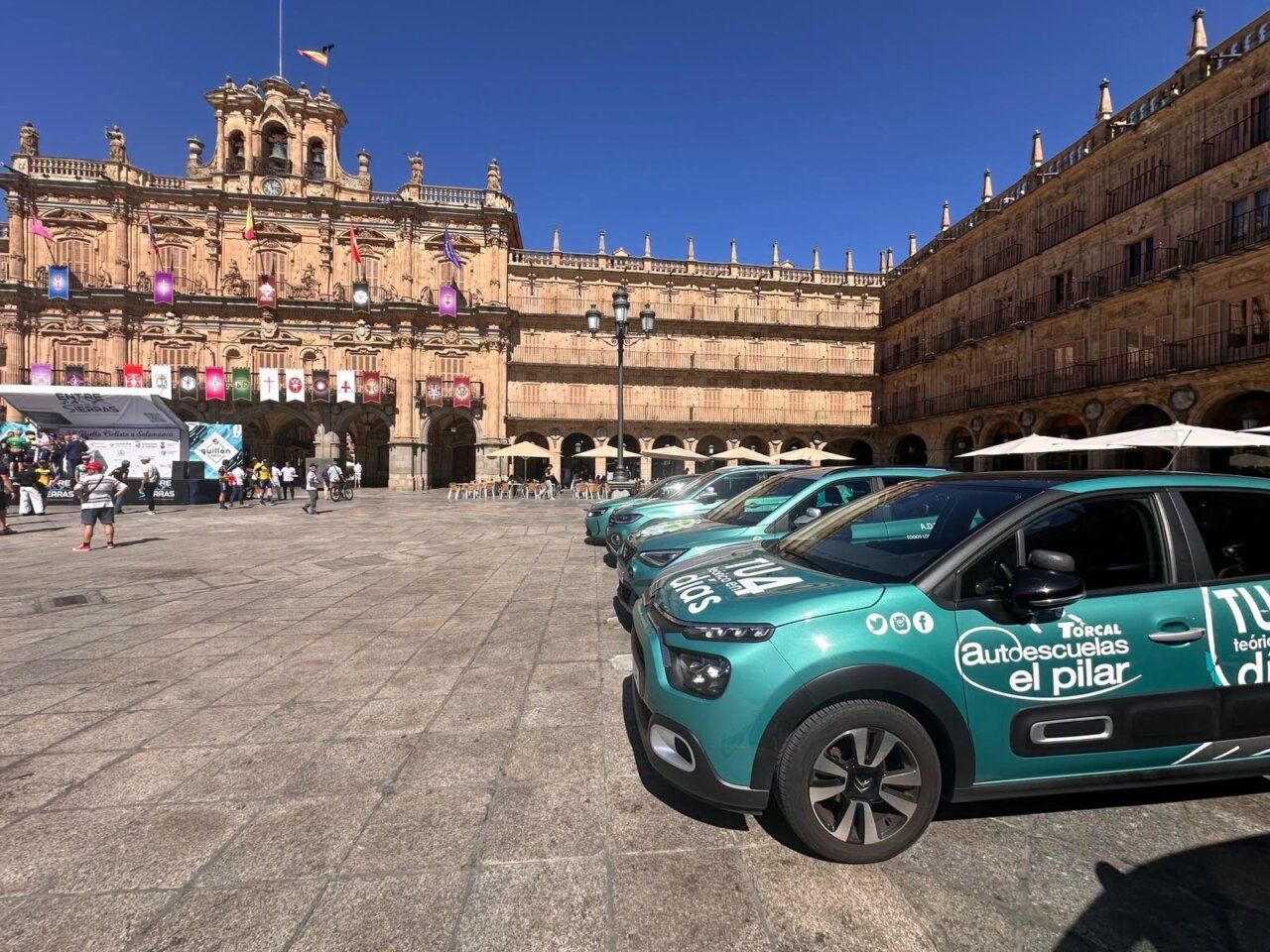Coches de Autoescuelas El Pilar en la plaza de Salamanca durante la Vuelta Ciclista.