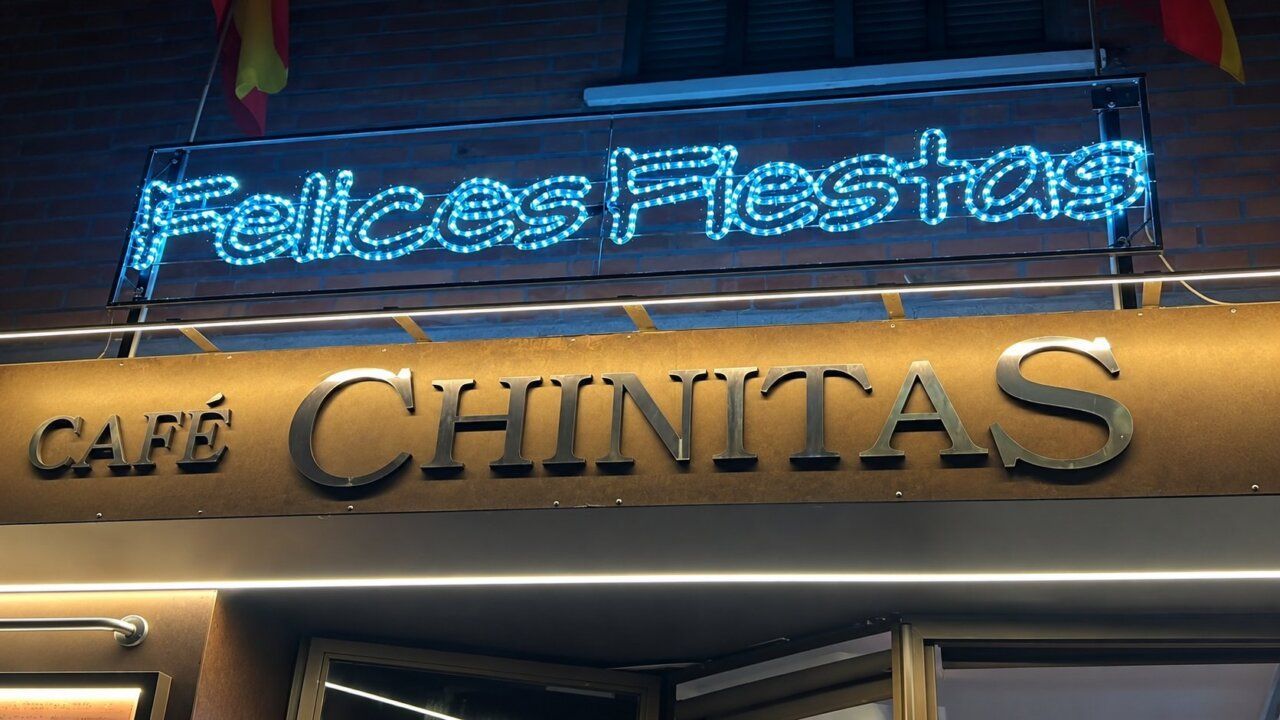 Cartel luminoso que dice Felices Fiestas en el Café Chinitas