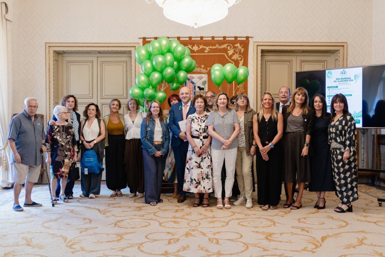 Grupo de personas en el Día Mundial del Alzheimer en Salamanca con globos verdes.