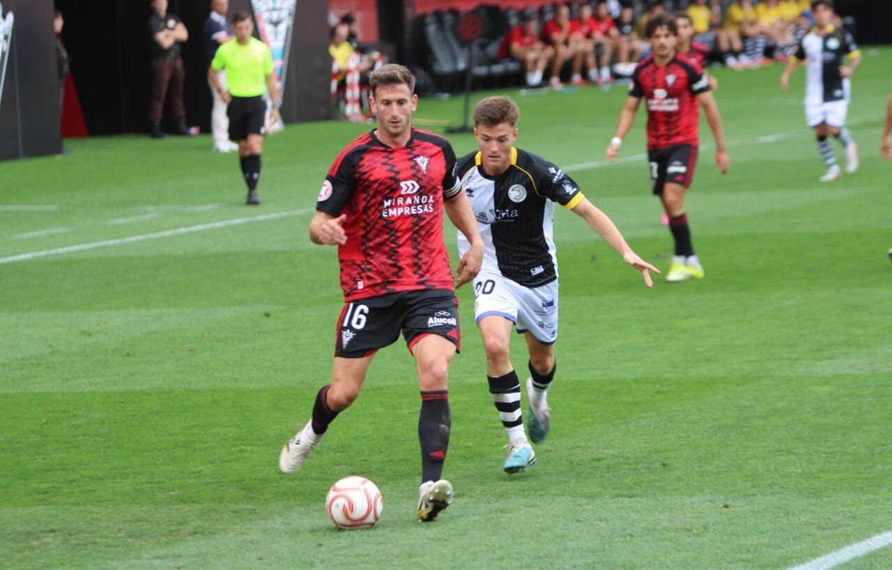Jugador del Mirandés corriendo con el balón durante un partido de fútbol