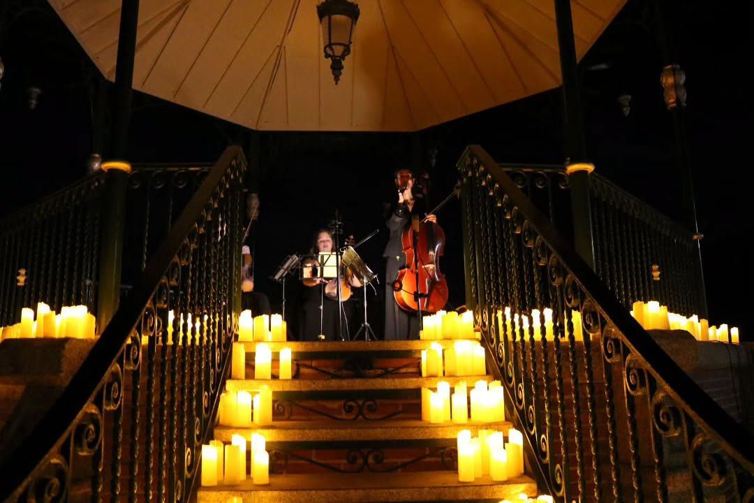 Músicos tocando en un escenario iluminado por velas en Peñaranda de Bracamonte