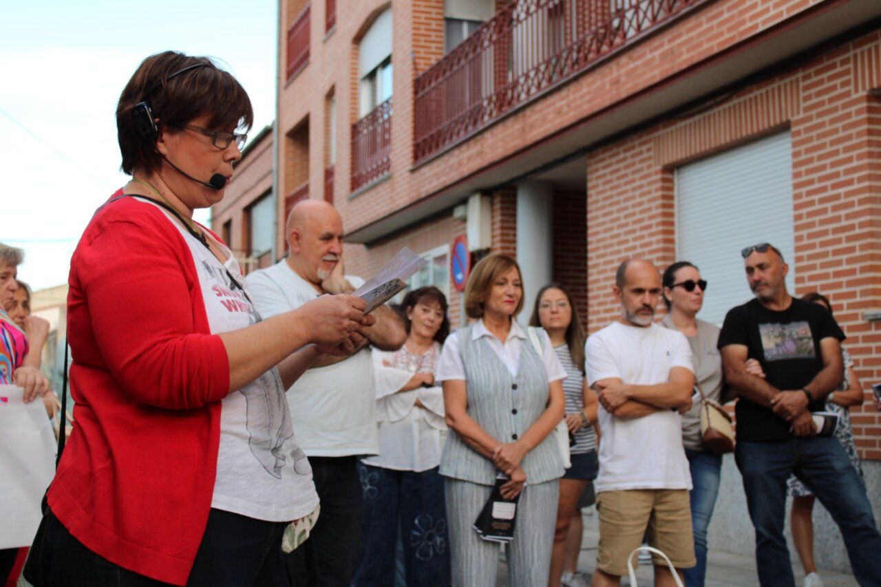 Mujer leyendo en un evento de las Fiestas de San Miguel con público atento.