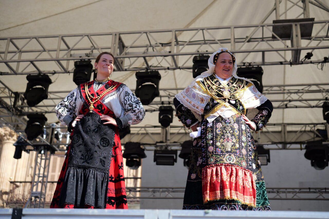 Dos mujeres vestidas con trajes tradicionales en un escenario
