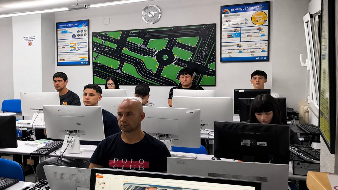 Estudiantes en aula de conducción preparándose para el examen de manejo