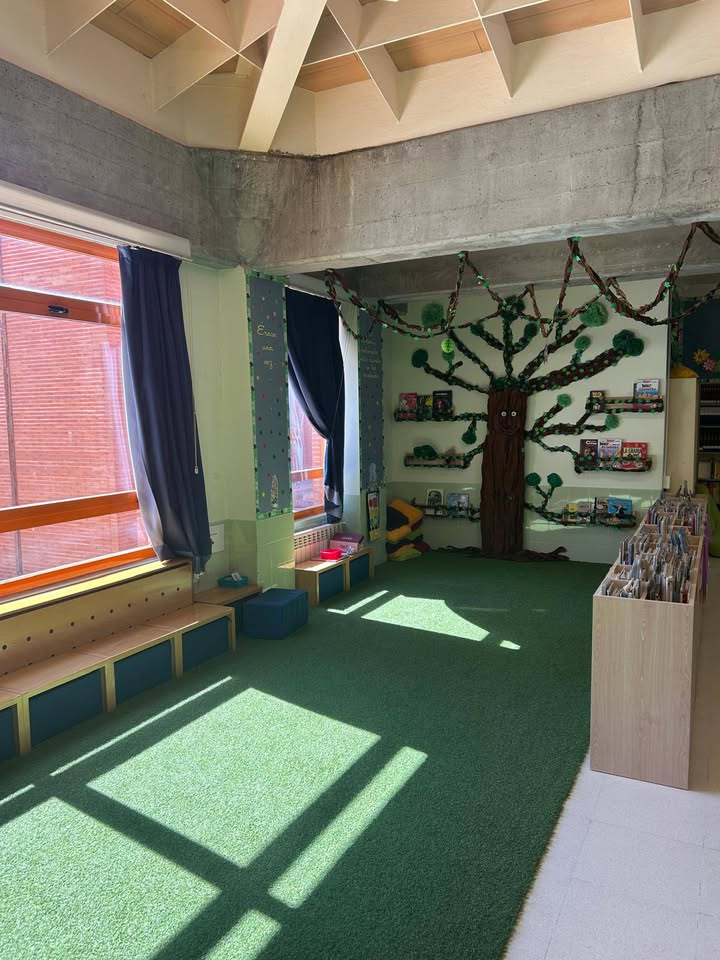 Interior de la biblioteca del CEIP Pablo Picasso con estantes de libros y decoración infantil.