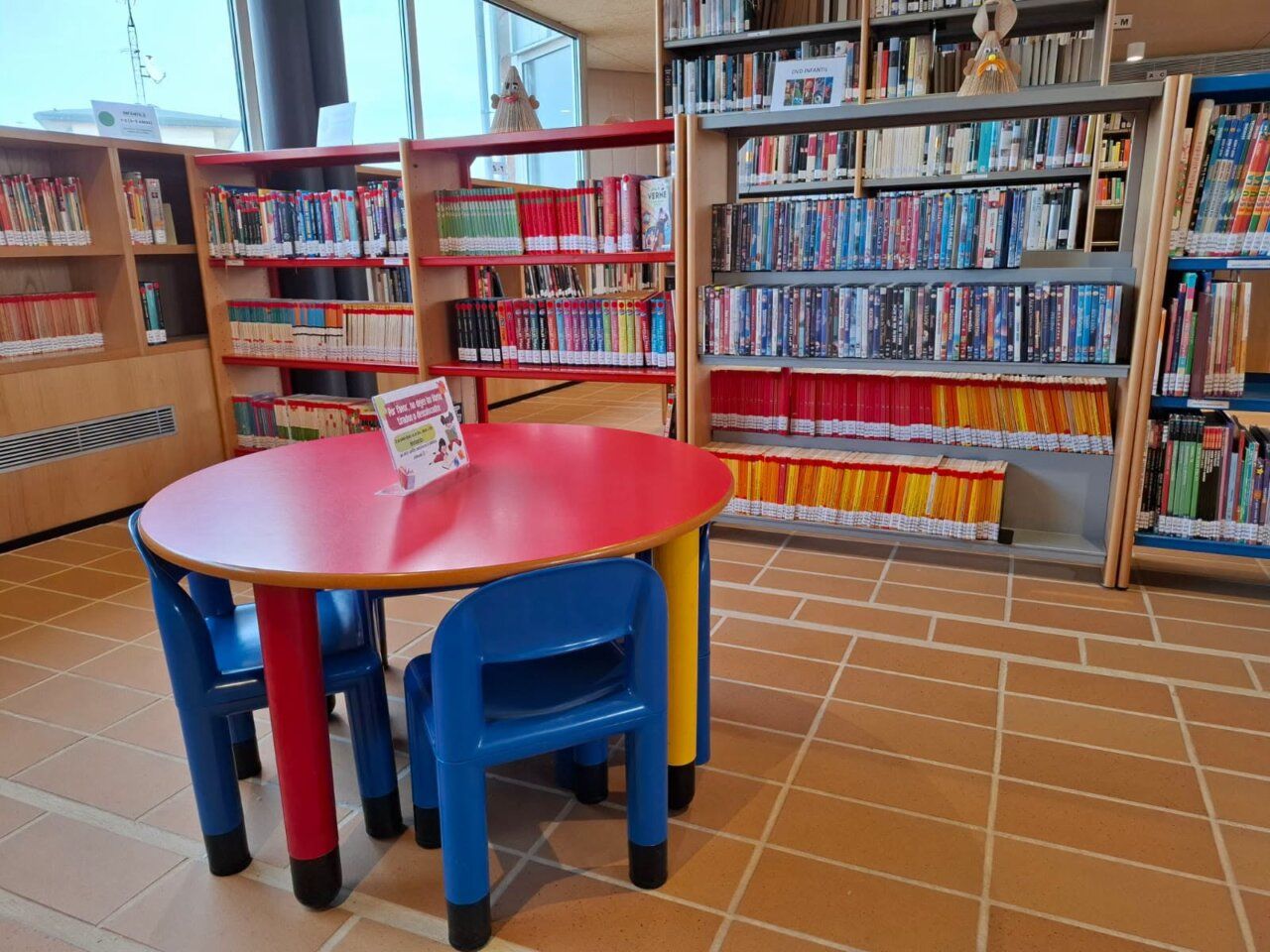 Interior de la biblioteca municipal de Carbajosa con estanterías y mesas