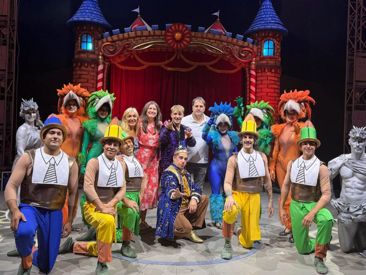 Actuación del circo estelar con un grupo de artistas en coloridos trajes.
