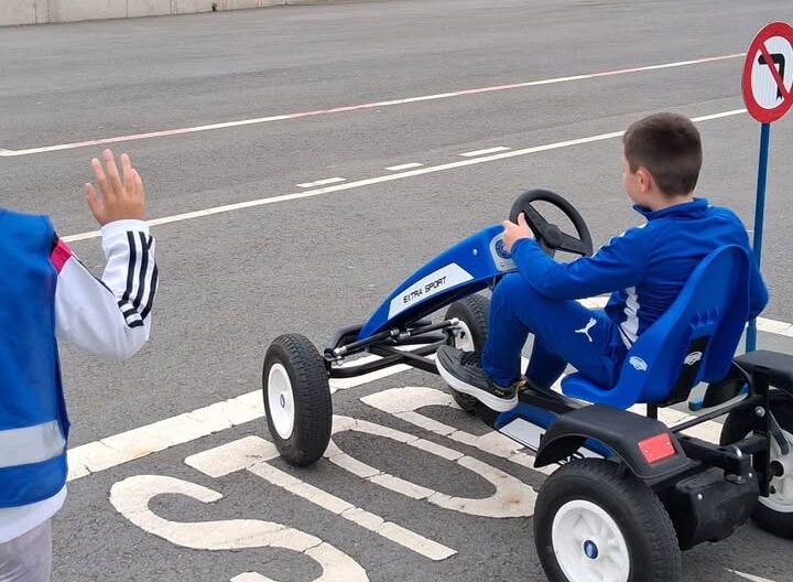 Niño conduciendo un kart en un circuito de educación vial