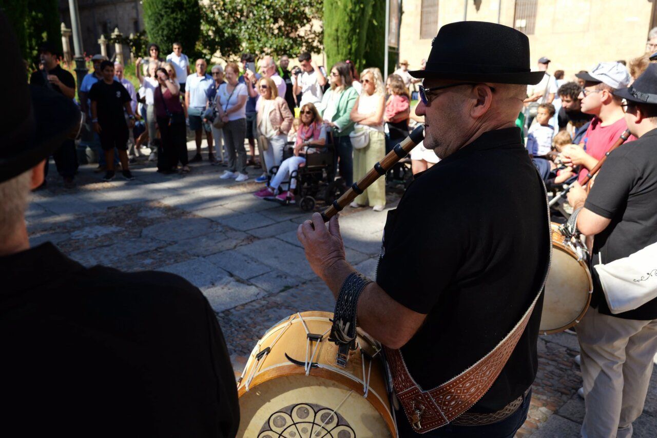Músico tocando flauta en las Ferias de Salamanca con público alrededor.