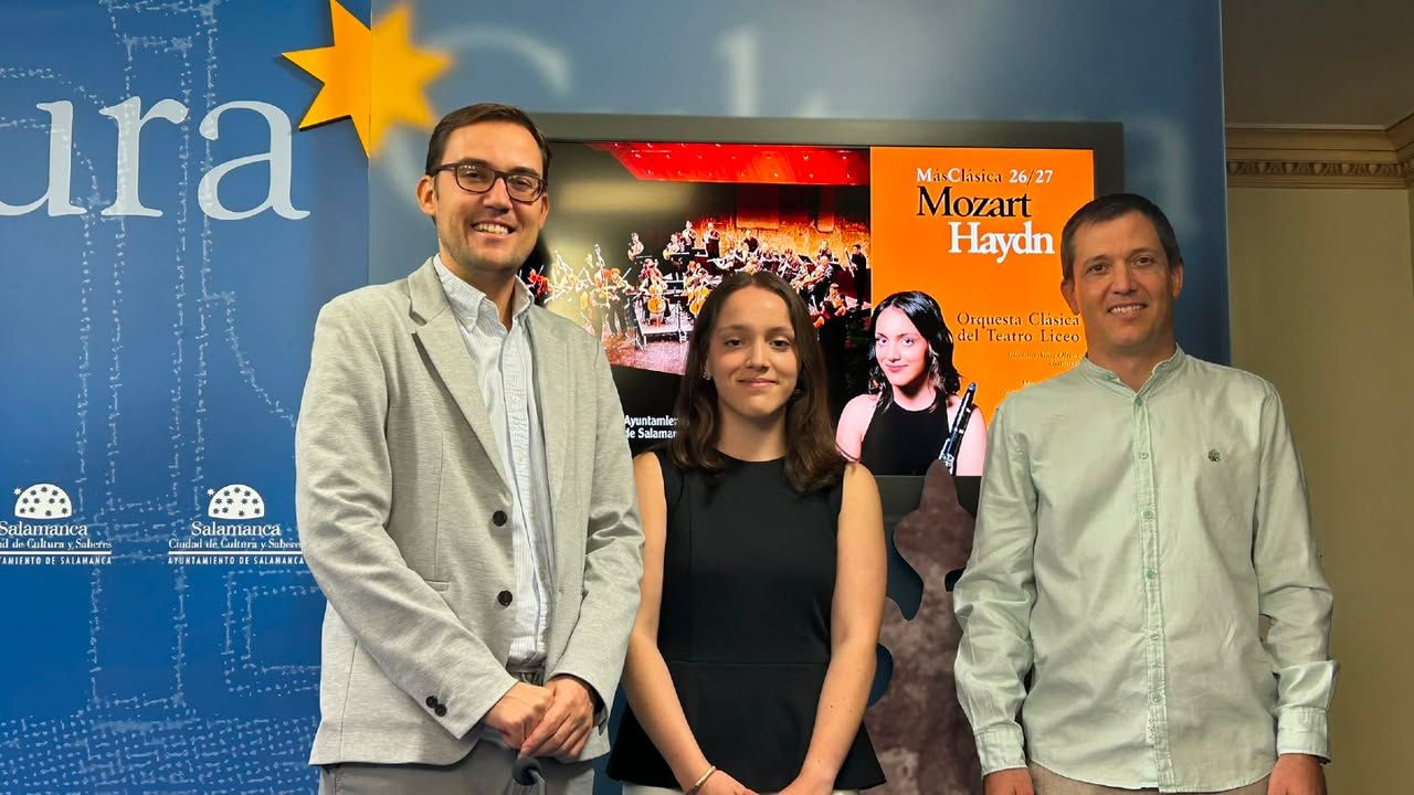 Tres personas posando frente a un cartel de la Orquesta Clásica del Teatro Liceo