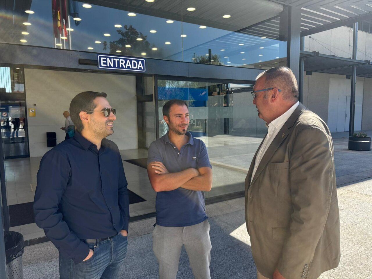 Tres hombres conversando en la entrada de un edificio en Salamaq.