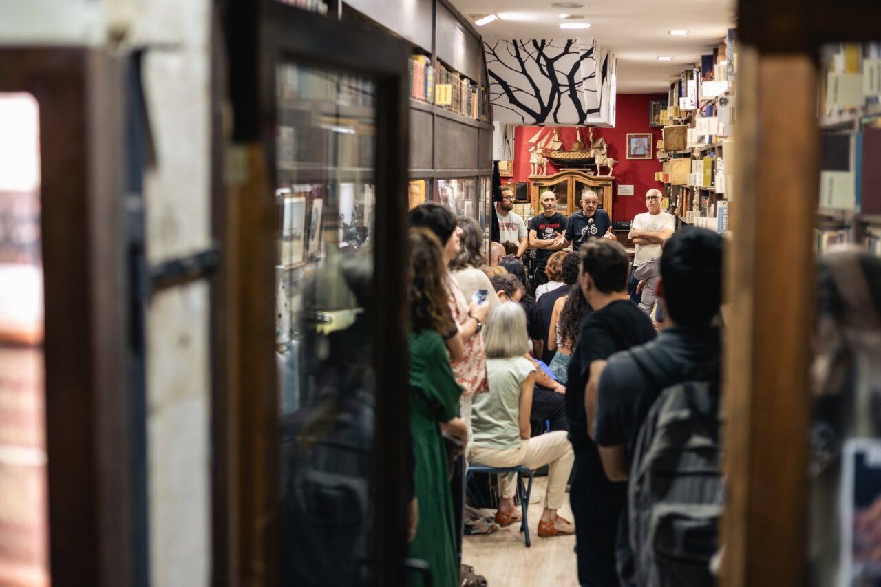 Recital poético en La Nave Librería Anticuaria con varios participantes.