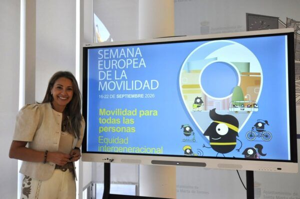 Mujer sonriente junto a un cartel de la Semana Europea de la Movilidad