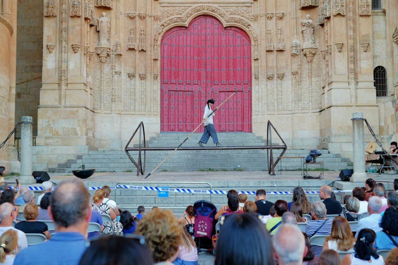 Artista caminando sobre una barra en el festival de artes de calle