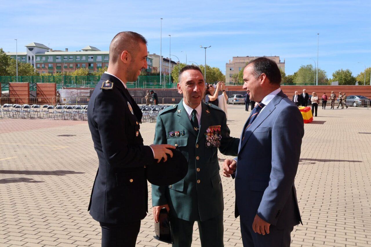 Tres hombres conversando durante un homenaje a la Guardia Civil en Salamanca.