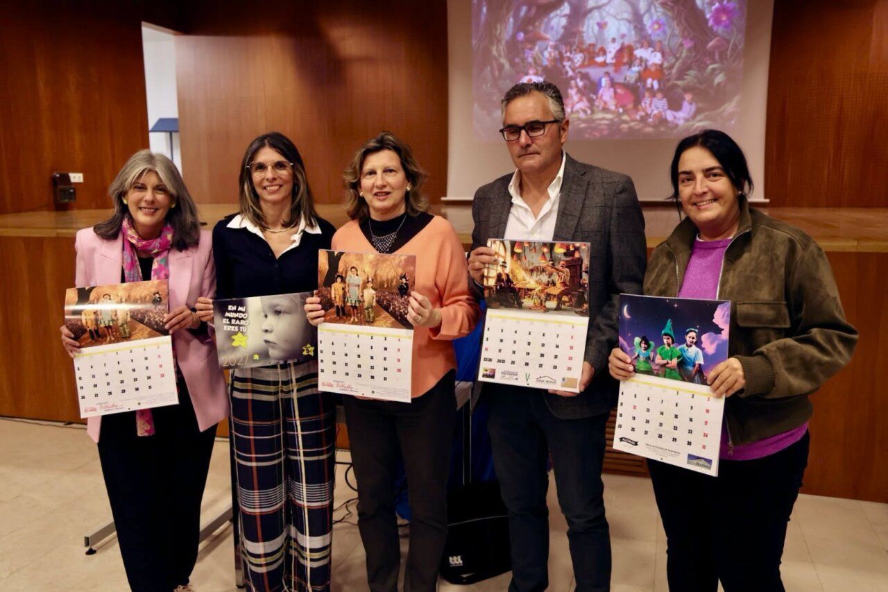 Cinco personas sostienen calendarios ilustrados frente a una pantalla proyectada.