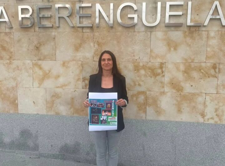 Mujer sosteniendo un cartel frente al Auditorio Reina Berenguela