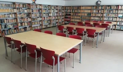 Interior de la Biblioteca Municipal de Cabrerizos con mesas y estanterías llenas de libros.