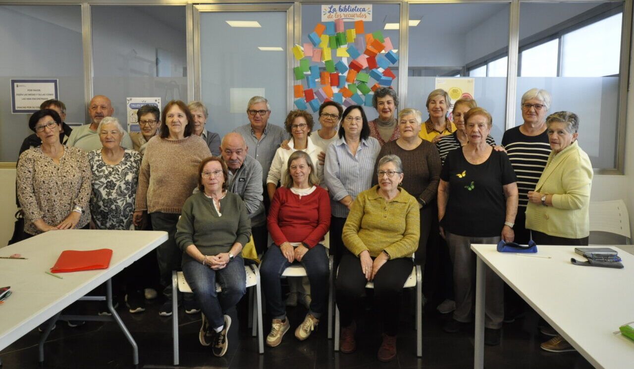 Personas posan frente a un mural de notas en una sala.