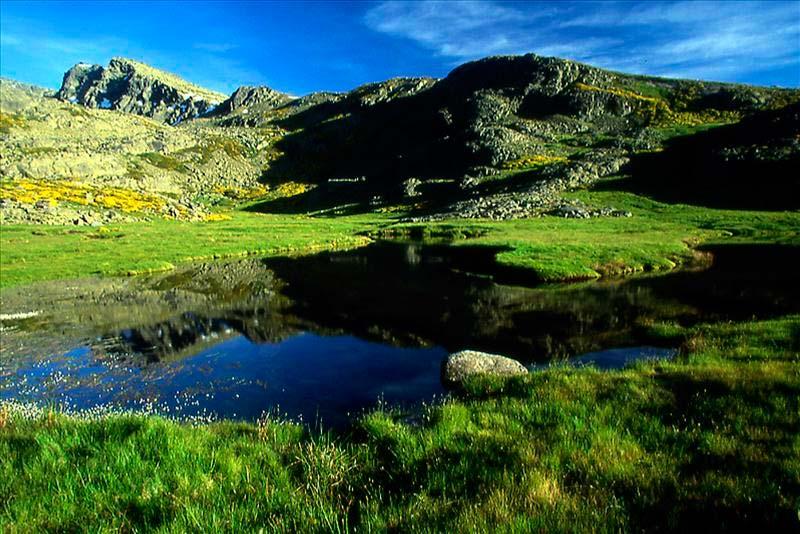 Paisaje de Candelario con montañas y un lago reflejante