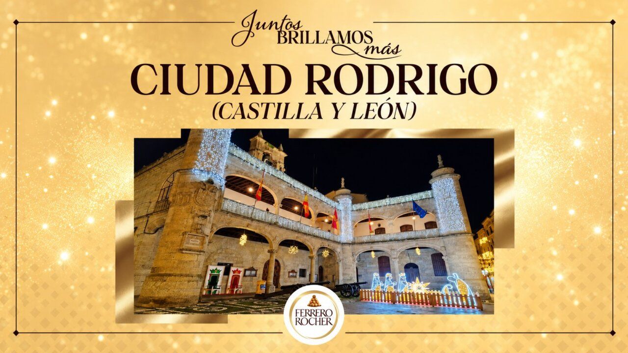 Cartel dorado de Ciudad Rodrigo con una fotografía de un edificio iluminado con luces navideñas.