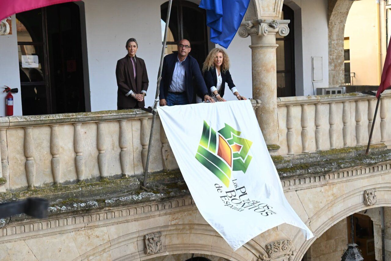 Personas desplegando una bandera en la celebración del Día de Los Pueblos Más Bonitos de España.