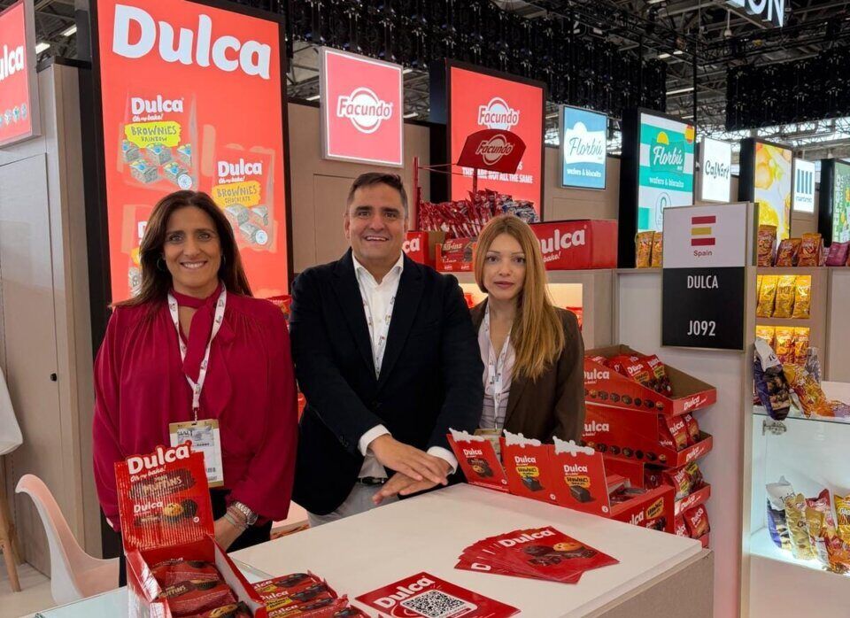 Tres personas posan en un expositor de Dulca con productos envasados.