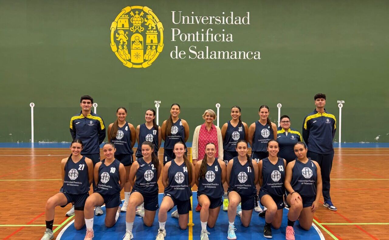 Fotografía de un equipo de baloncesto posando en una cancha bajo el emblema de la UPSA