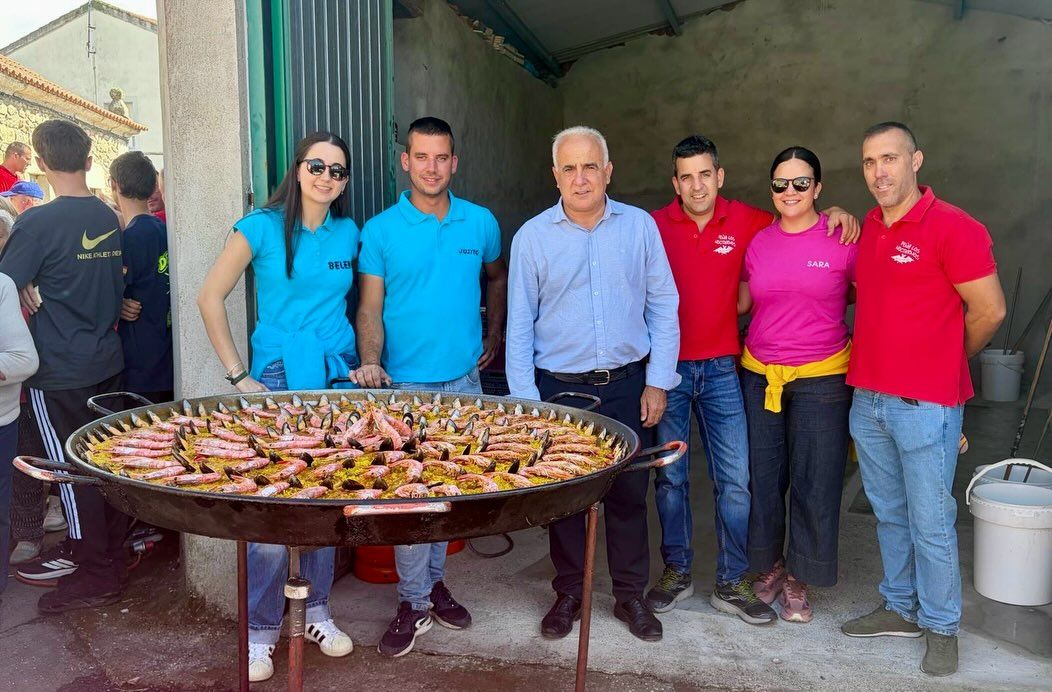 Grupo de personas junto a una gran paella en las Fiestas de las Madrinas