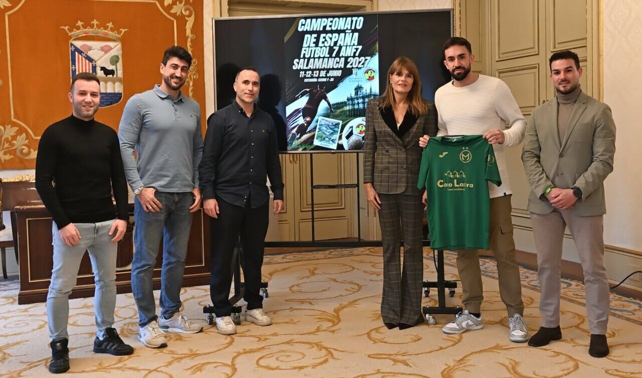Seis personas posan junto a una camiseta verde y un cartel del campeonato de fútbol 7