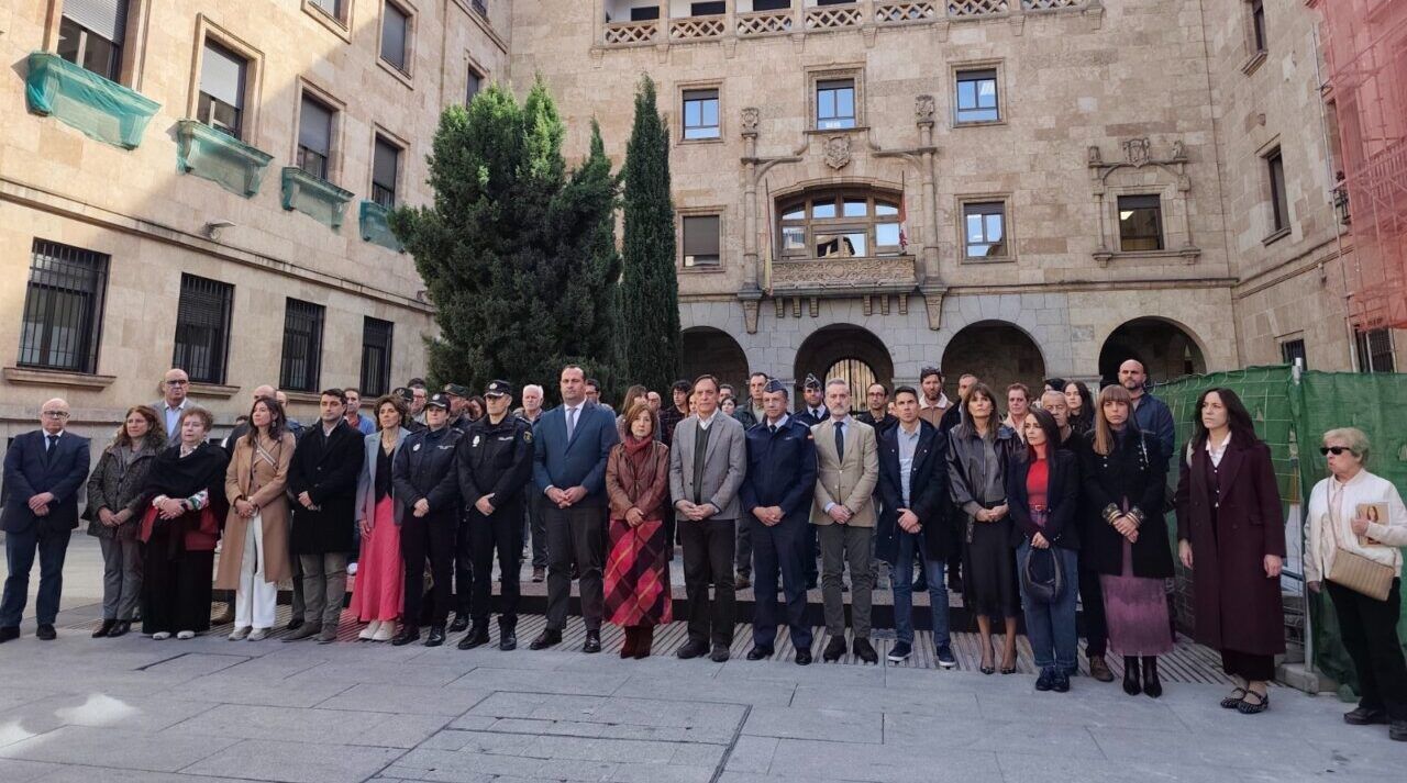 Grupo de personas reunido en el patio de un edificio de piedra.
