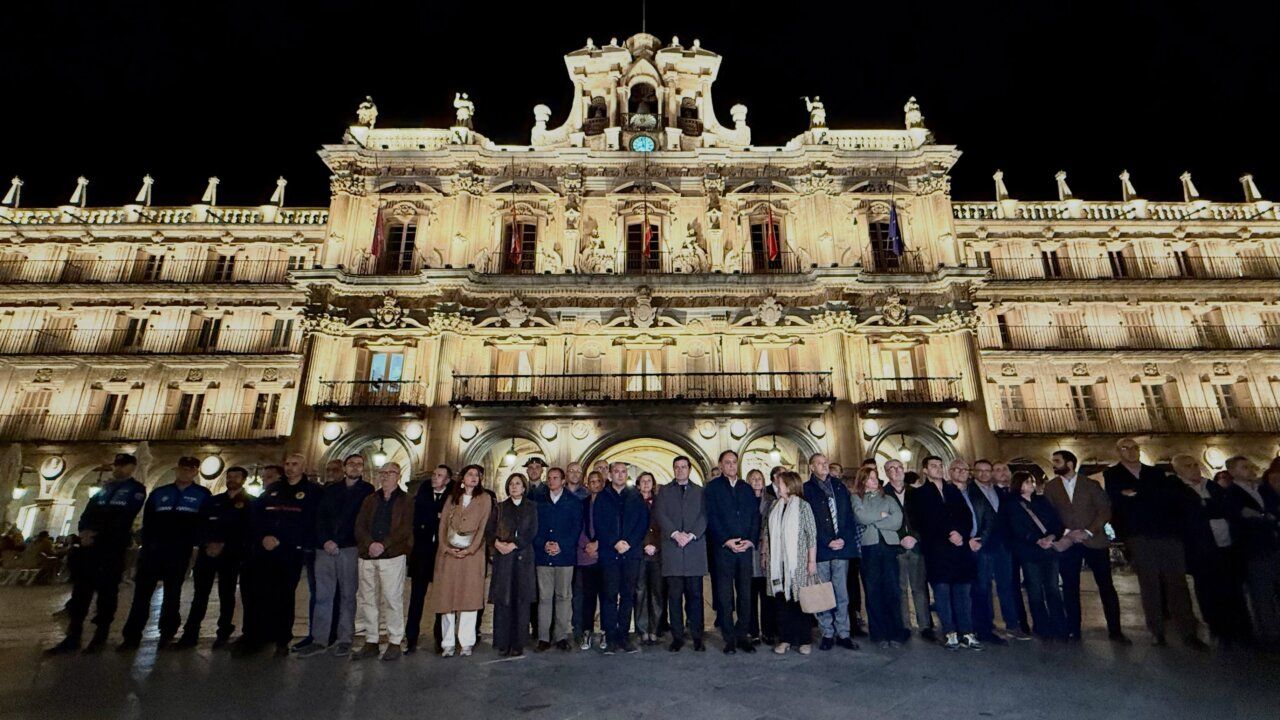 Personas reunidas frente a la fachada iluminada del Ayuntamiento de Salamanca por la noche